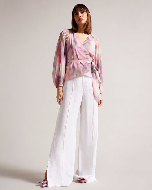 EMILIAH-Tops-Add some spring florals to your wardrobe with our EMILIAH blouse, which features a wrap front and blouson sleeves. Smocked shoulders give the piece extra texture without the bulk.The fabric of this product is made with 100% recycled polyester. Using recycled polyester helps divert plastic waste from ending in landfills, and helps us to reduce our dependence on virgin materials. Blouse Wrap front Blouson sleeves Smocked shoulders Blurred floral print Self tie waist V-neck Julia is 5'10" / 1.78m
